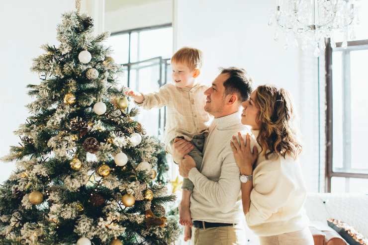 famiglia che addobba l'albero di natale